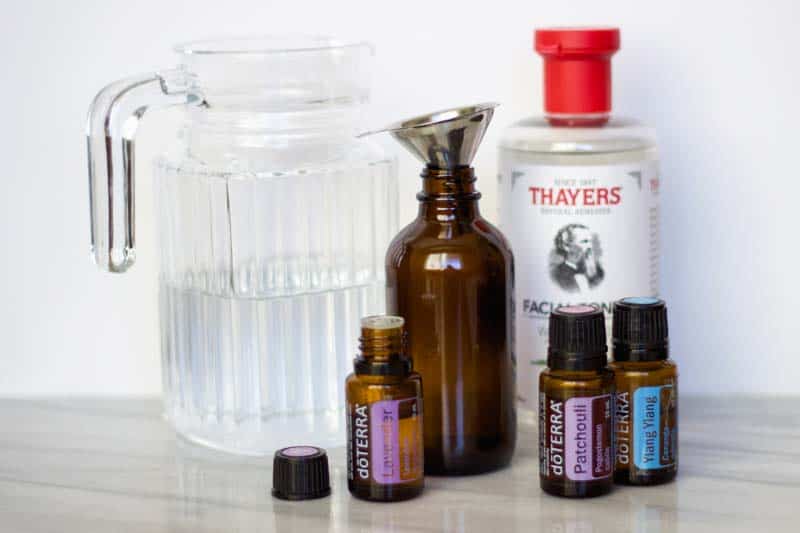 ingredients to make diy room spray: distilled water, Thayer's witch hazel, essential oils, funnel, 4-ounce glass spray bottle