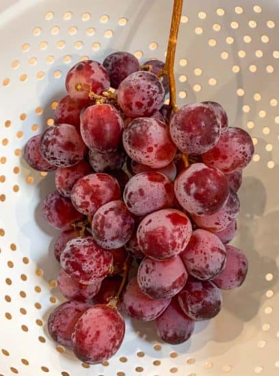 bunch of red grapes, unwashed, with visible white bloom