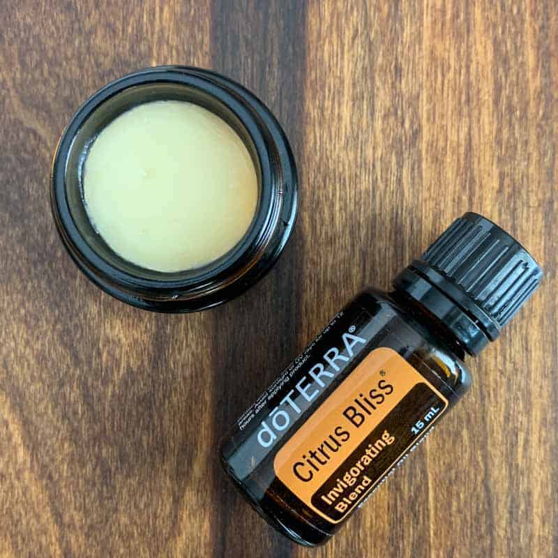 DIY Lip Balm in an amber glass pot beside doTERRA Citrus Bliss essential oil